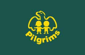 A yellow graphic of an eagle with outstretched wings stands behind two children holding hands, one wearing a cap. The word Pilgrims is curved below them, all set against a dark green background.